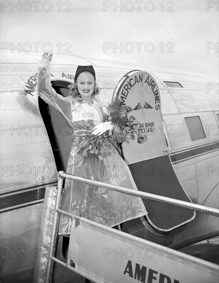 Miss Marion Weldon, Paramount starlet, waves a greeting to the throng as she arrived at Washington Airport today to participate in National Airmail Week circa 1938.