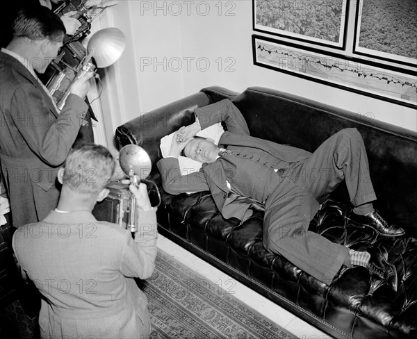 Senator Allen Ellender Democrat of Louisana and onetime Lieutenant of the late Huey Long, is snapped by news cameramen as he rests in his office  circa 1938.