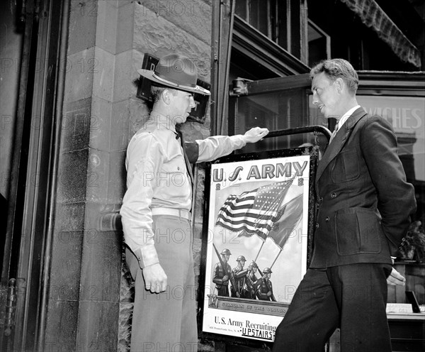 A PFC is talking to a young man about enlisting in the U.S. Army circa 1940.