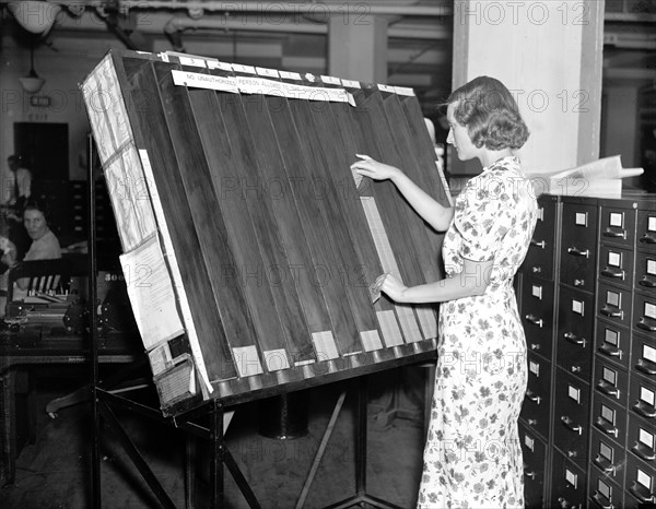 Social Security History - a worker in the Social Security Board Records Office at work at the 'visible control' rack circa 1937 or 1938 .