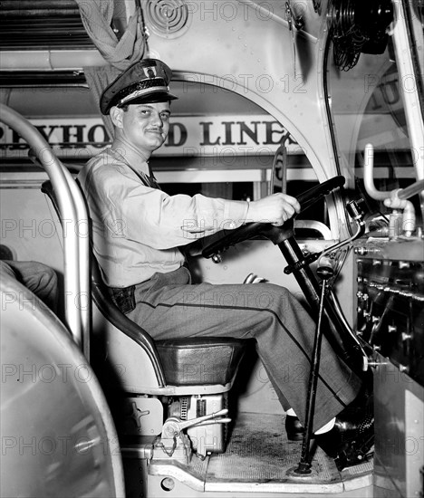 Greyhound Bus lines bus driver sitting at the steering wheel  circa 1937.