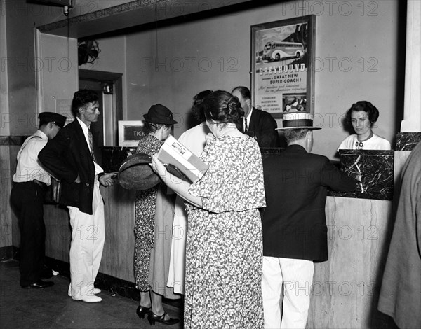 Customers waiting to buy tickets at Greyhound Bus Station ticket counter circa 1937.