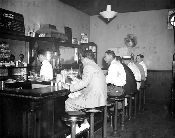 Men eating at lunch counter of restaurant inside Greyhound Bus Terminal circa 1936 or 1937.