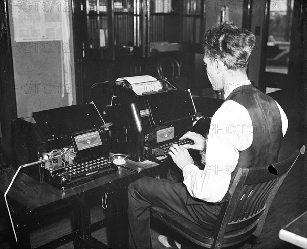 Worker operating a new radio teletypewriter service which allows for instantaneous transmission of written records without the aid of wires, has been perfected by the experts of the Bureau of Air Commerce circa 1936.