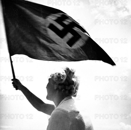 Woman waving Nazi flag circa late 1930s or early 1940s.
