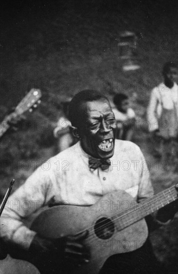 Stavin' Chain playing guitar and singing the ballad 'Batson,' Lafayette, La. June 1934.