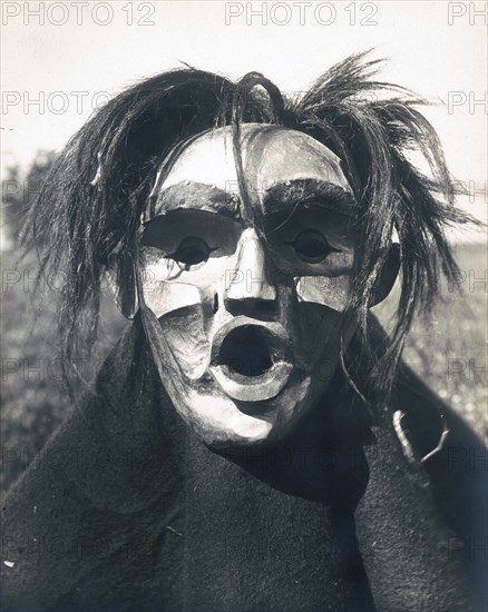 Edward S. Curits Native American Indians - Person wearing Mask of Tsunukwalahl, a mythical being, used during the Winter Dance circa 1914.