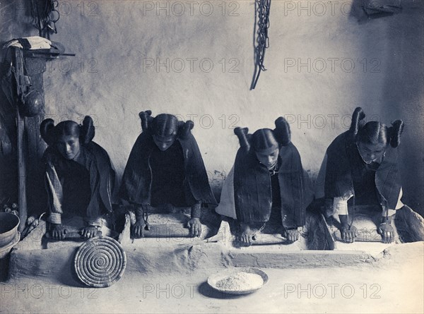 Edward S. Curtis Native American Indians - four young Hopi Indian women grinding grain circa 1906.