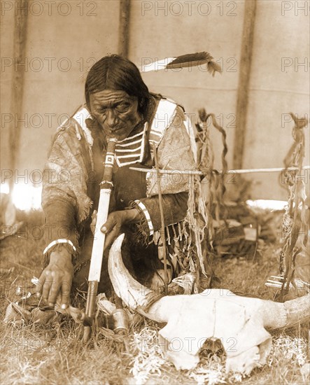 Edward S. Curtis Native American Indians - Dakota man with calumet kneeling by altar inside tipi circa 1907.