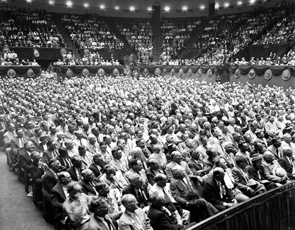 Crowd of people listening to a speaker (not in photo)  circa 1935.