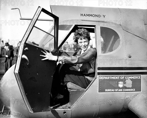 Amelia Earhart in airplane, looking at camera circa 1936.