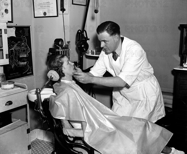 Dentist examining a patient circa 1936.