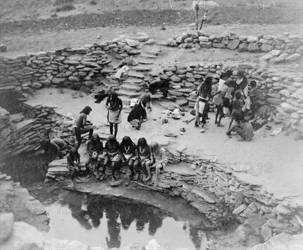 Edward S. Curtis Native American Indians -  Hopi Indians gathered at oasis, some seated at water, others standing in background circa 1905.