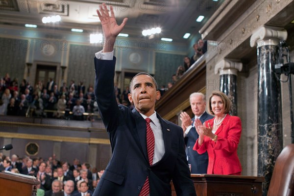 President Barack Obama waves to the First Lady and guests seated in the gallery of the House Chamber at the U.S. Capitol in Washington, D.C., Sept. 9, 2009. IN the background are Vice President Joe Biden and Speaker of the House Nancy Pelosi..