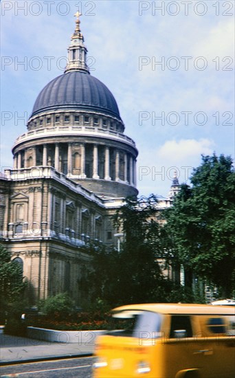 Yellow Van driving by unidentified building in UK circa 1973.