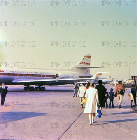 Airplane passengers walking on the tarmac at the Madrid Spain airport before boarding a plane circa 1969.