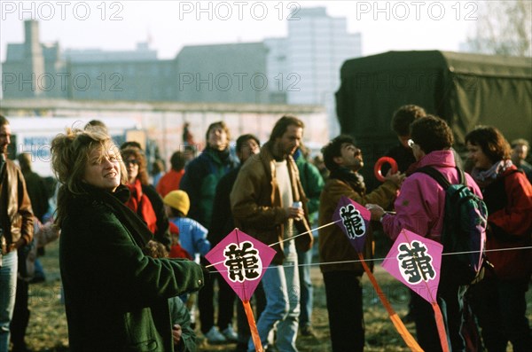 An East German woman holds onto a kite string as she celebrates the demolition of a section of the Berlin Wall at Potsdamer Platz..