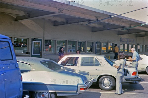(R) New York 1975 - Cars parked at the Canada Customs station, travlers .