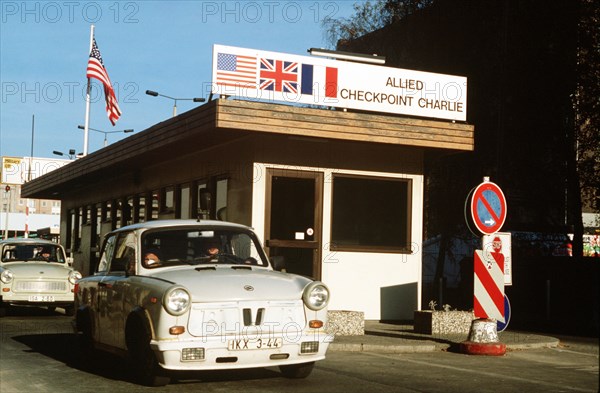 East Germans drive their vehicles through Checkpoint Charlie as they take advantage of relaxed travel restrictions to visit West Germany..