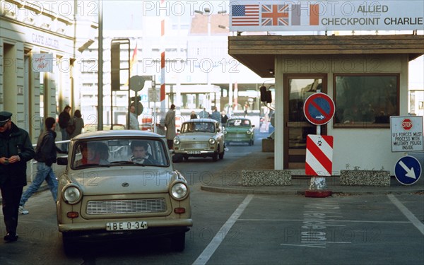 East Germans drive their vehicles through Checkpoint Charlie as they take advantage of relaxed travel restrictions to visit West Germany..