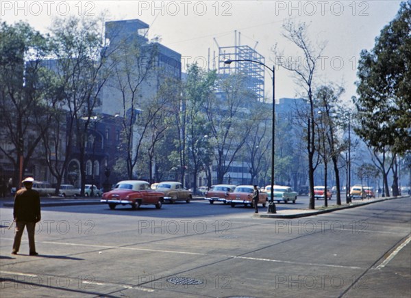1962 Historical Photo -  1960s traffic filled with pastel colored automobiles in a large Latin American city in 1962.