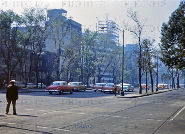 1962 Historical Photo - 1960s traffic filled with pastel colored automobiles in a large Latin American city in 1962.