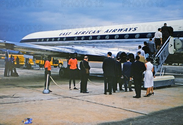 1961 Africa - Passnegers on a tarmac boarding an East African Airways airplane .