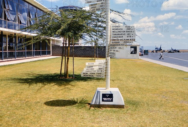 1961 Africa - International distance signs at an airport in Nairobi Kenya (Possibly Wilson Airport).