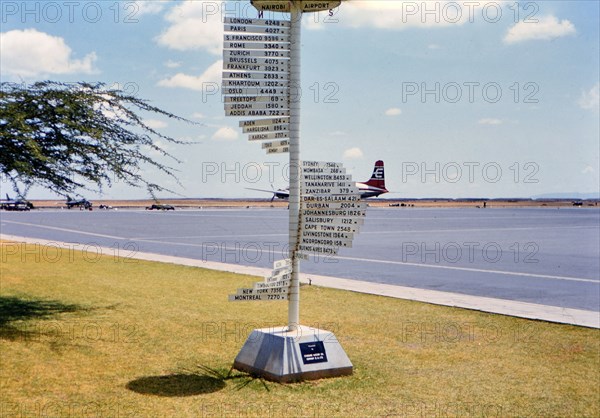 1961 Africa - International distance signs at an airport in Nairobi Kenya (Possibly Wilson Airport).