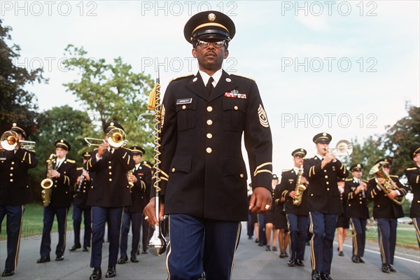 1977 - A drum major leads a US Army band while marching in formation.