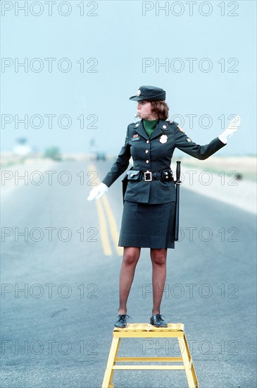 1979 - A U.S. Army military policewoman directs traffic.