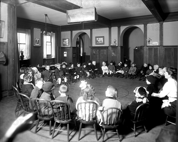 Little kids sitting in a circle in chairs