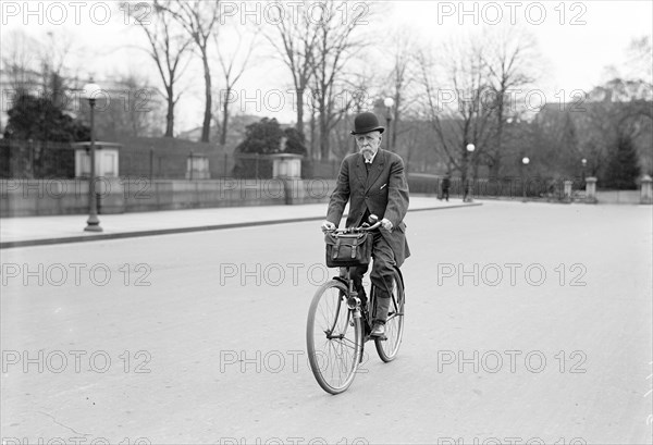 Old man riding his bicycle to work on a city street