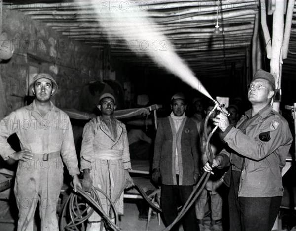 Spraying enlisted men's barracks with DDT at 3rd Platoon