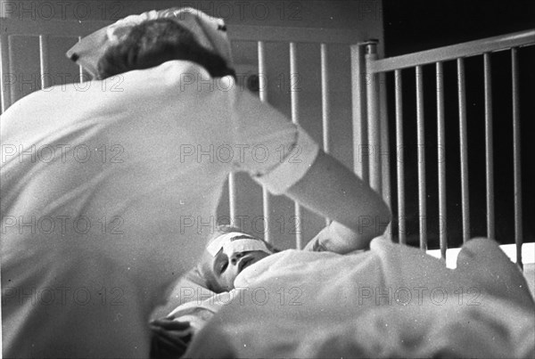 Nurse with small child with eye bandage.