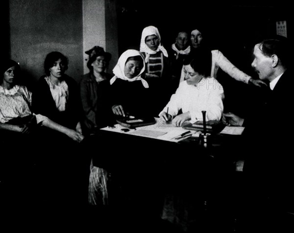 A female immigrant piecing together a wooden puzzle as part of an examination.