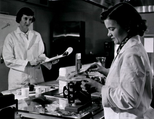 Two female dietitians weigh and measure foods