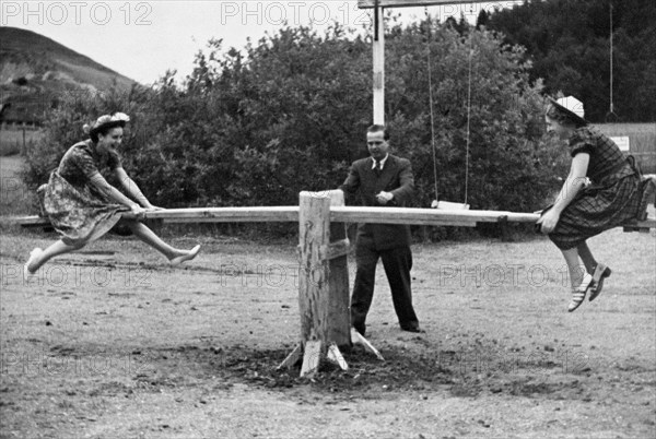 Girls playing on see saw or teeter totter in Germany