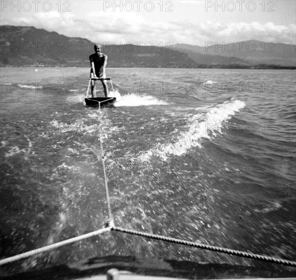 Man skiing behind boat on a board