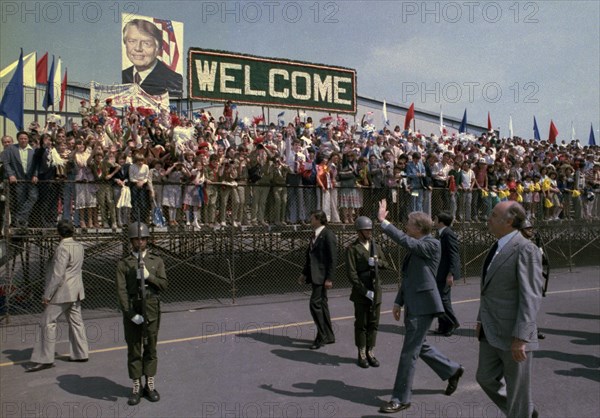 Jimmy Carter and Lopez Portillo wave during arrival ceremony for state visit to Mexico.