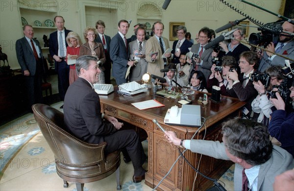 President Reagan in the oval office with the press corps.