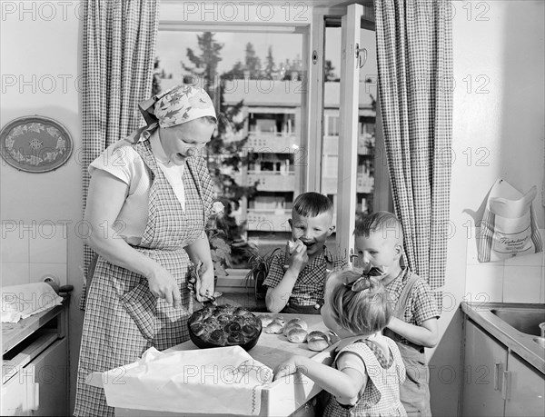 Mom bakes children's buns in the kitchen