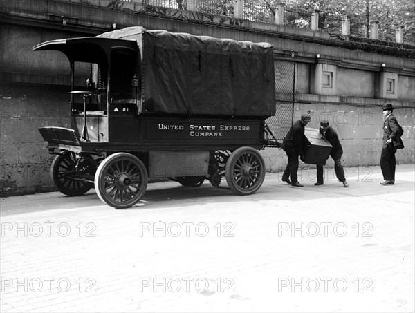 Workers loading a trunk onto a United States Express Company truck ca. 1913