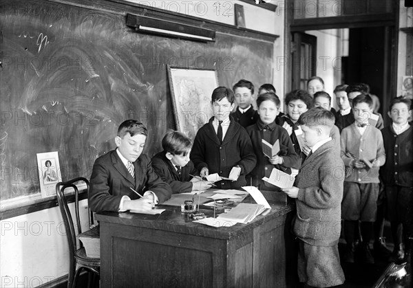 Children in classroom with chalkboard ca. 1915