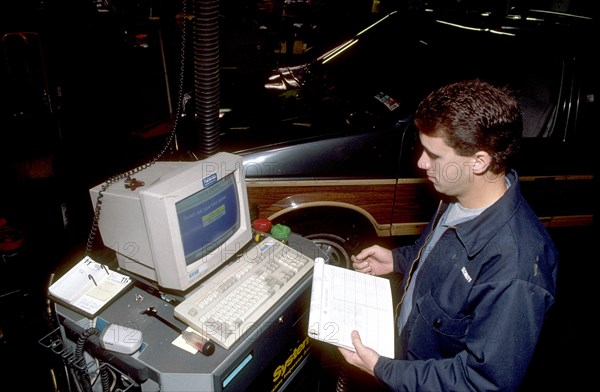 Technician performing an emissions test on a vehicle