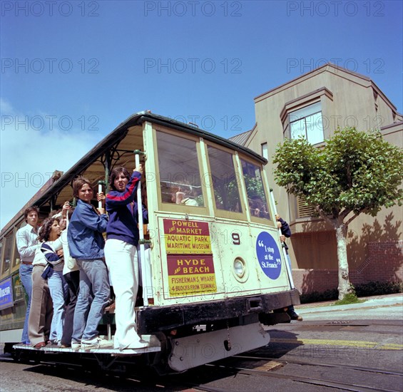 Tourists riding the famous San Francisco cable car