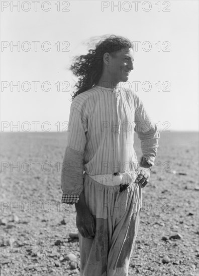 Bedouin life in Trans-Jordan, a bedouin road bulder with long hair in Trans-Jordan ca. 1920