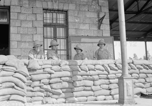 Soldiers standing behind sand-bag barricade in Lydda Israel at the railroad station ca. 1939