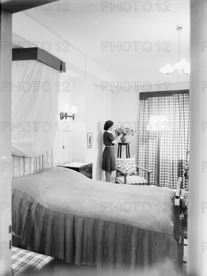 Woman in a home in Jerusalem arranging flowers in a room ca. between 1898 and 1946