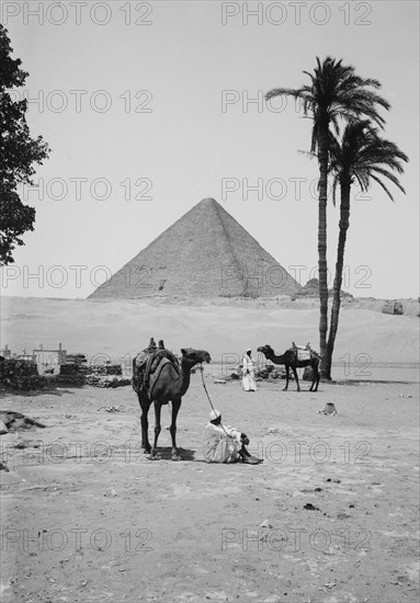 The pyramids of Gizeh,  Great Pyramid of Kheops [i.e., Cheops] and sphinx, men with camels in foreground  ca. 1900